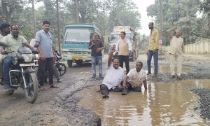 बदहाल सड़क पर जनता का अनोखा विरोध : कीचड़ भरे गड्ढों में लोटकर जताया आक्रोश, एक्सीवेटर चालक ने खुद भर दिए गड्ढे